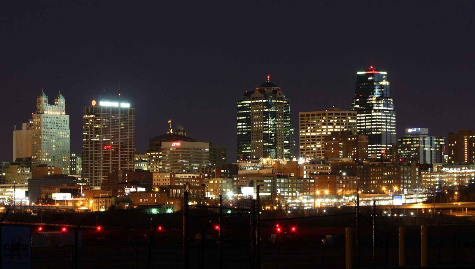 American city skyline lit at night with highway lights in the foreground