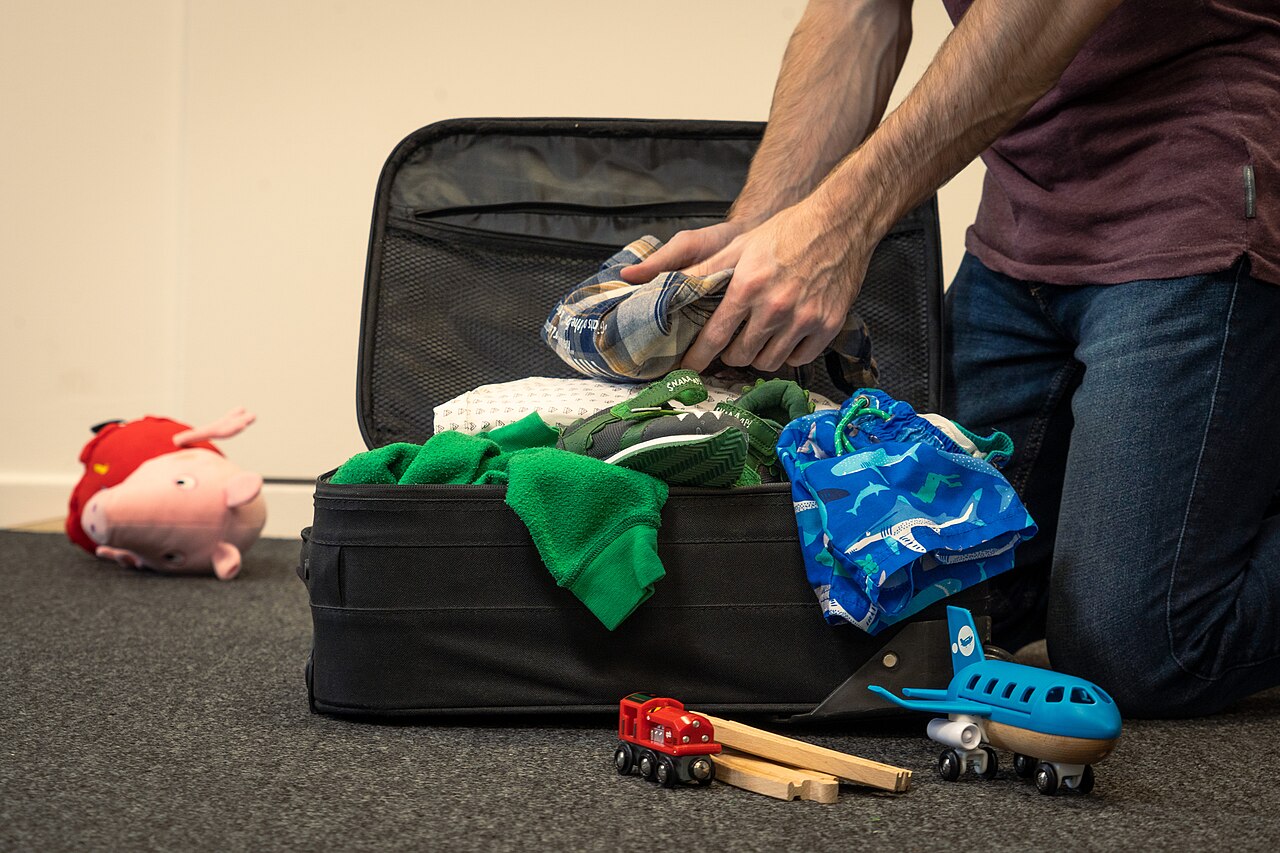 Open suitcase with neatly packed travel gear laid out for a trip